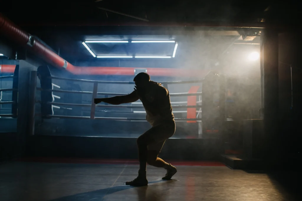a male boxer is boxing with a shadow on