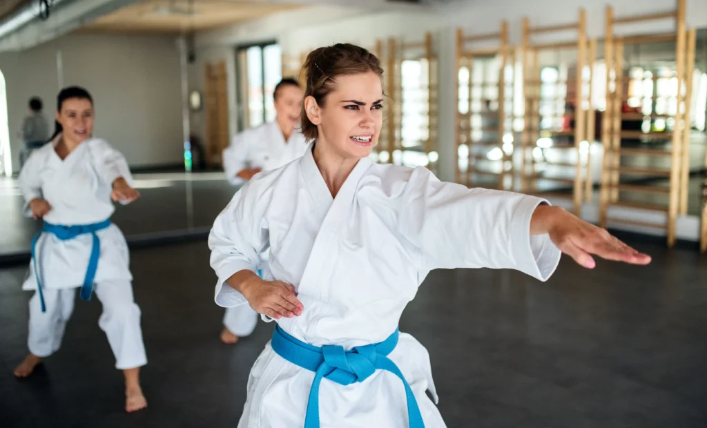 group of young women practising karate indoors