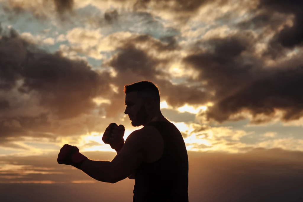 silhouette of male athlete in boxing gloves mma